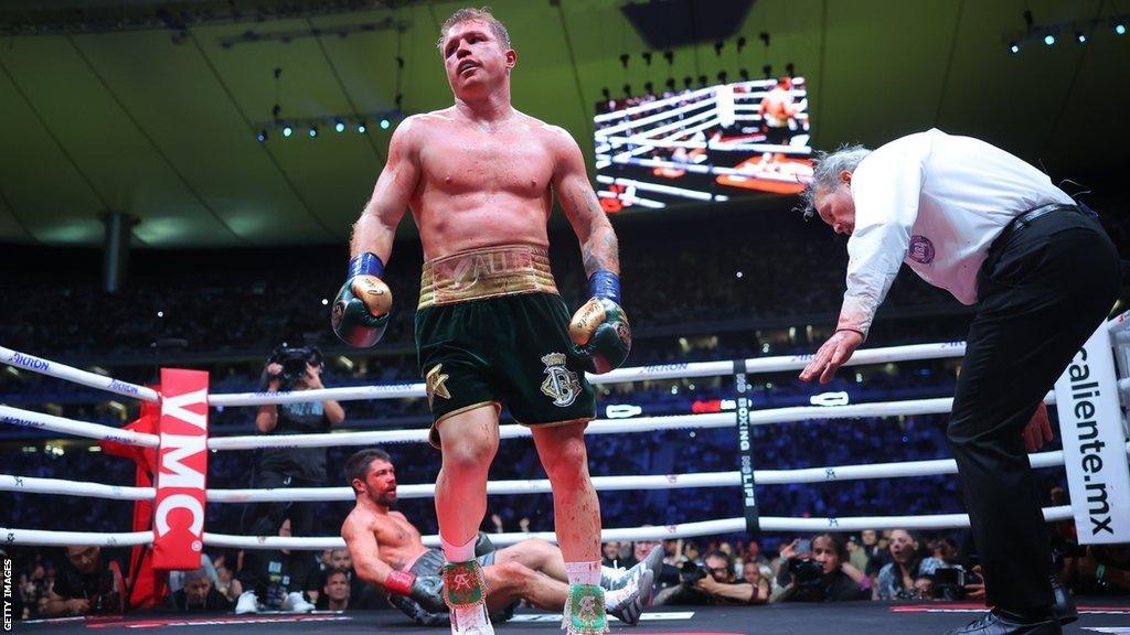 Saul 'Canelo' Alvarez stands as John Ryder lies on the canvas