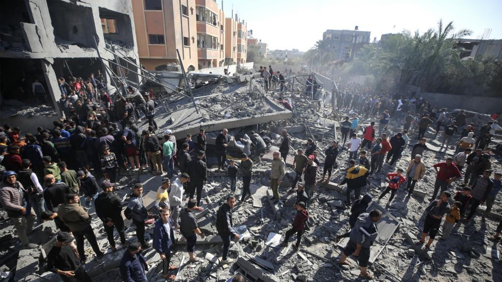 Palestinians search building rubble for survivors following Israeli strikes on al-Maghazi refugee camp in the central Gaza Strip