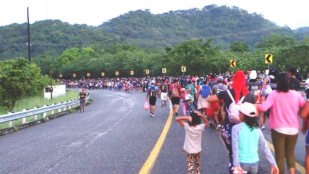 Migrants walk towards the US border