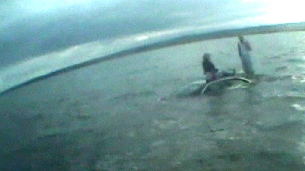 Pair on the roof of their submerged car