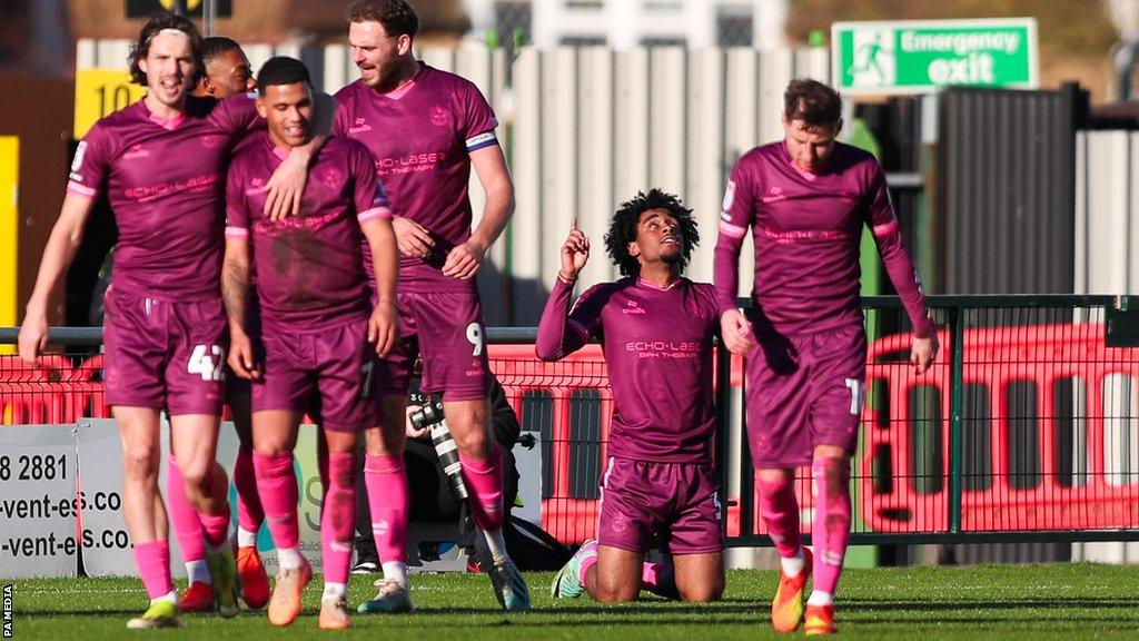 Sutton United's players celebrate after Nino Adom Malaki scores their third goal in a win against Accrington Stanley