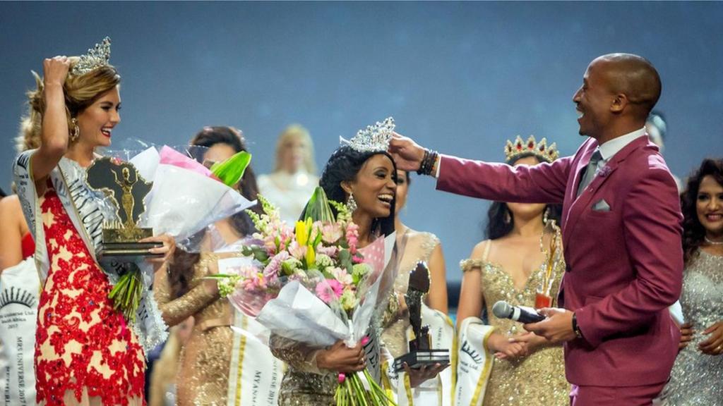 Mrs. Gabon Gwen Madiba reacts after her crown fell on the floor and is re- placed by television host and personality Arthur Evans (R) during the Mrs. Universe beauty pageant on September 02, 2017, at the International Convention Centre in Durban. Mrs. Universe must age 25 to 45, have a family, her own career, and be involved with a significant cause in favour of other people.