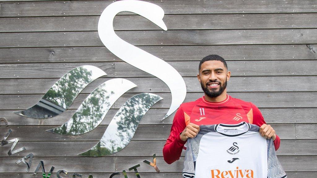 Josh Ginnelly poses with a Swansea City shirt