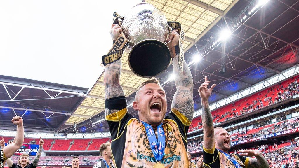 Josh Charnley helped Leigh win the Challenge Cup, which he is holding aloft on the pitch at Wembley