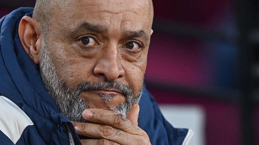 Close-up of Nuno Espirito Santo. He has a greying beard and is wearing a navy coat. He is resting one of his hands against his chin.
