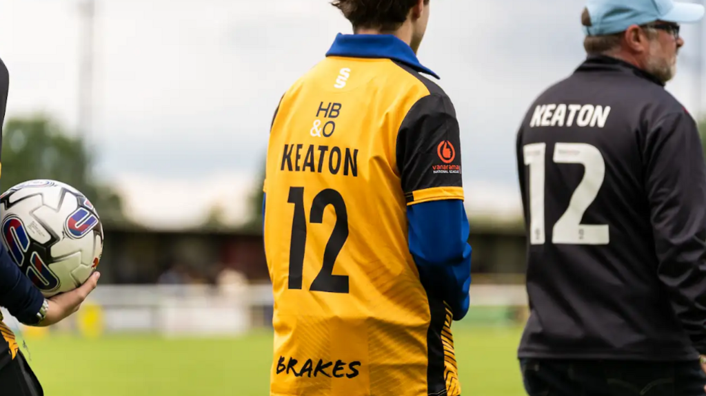 Two people on a football pitch with the name Keaton and number 12 on the back of their shirts