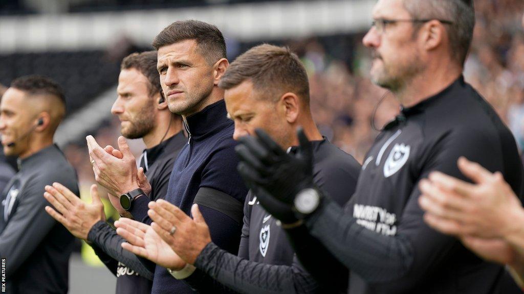 Portsmouth boss John Mousinho on the touchline with his coaching staff during a League One match.