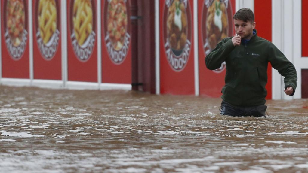 Man wades through flood water in Dumfries