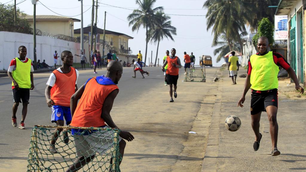 Liberians playing football on a street in Monrovia - January 2017