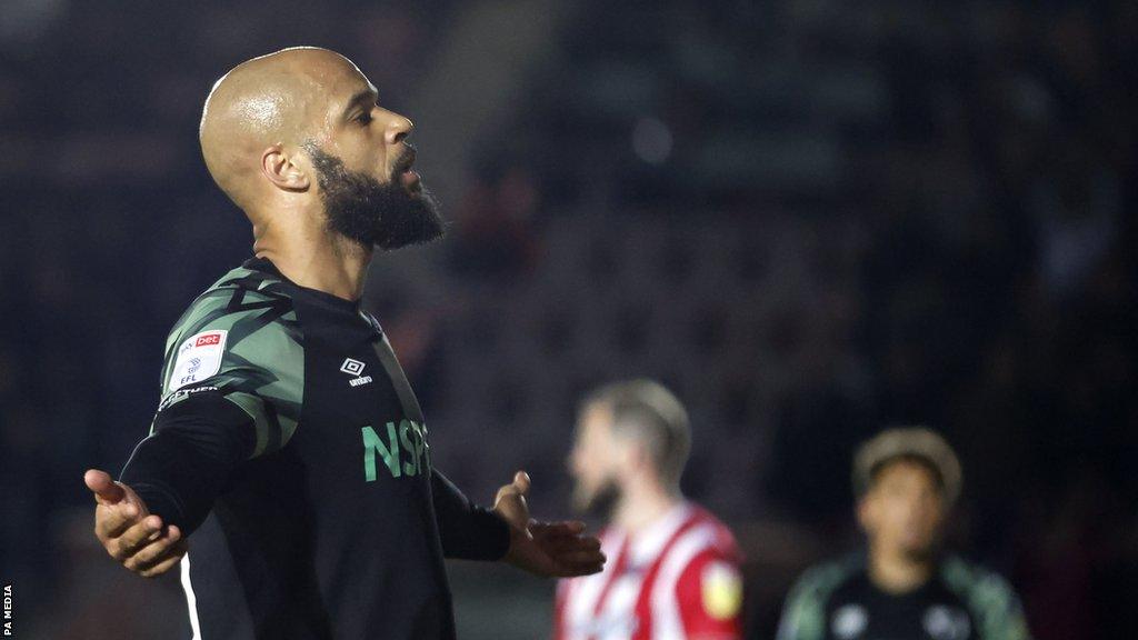 Derby County's David McGoldrick with his arms outstretched as he celebrates his goal at Exeter