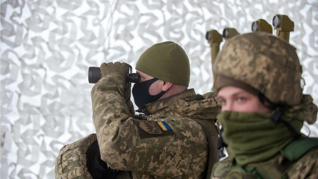 A Ukrainian Military Forces serviceman of the 92nd mechanised brigade uses binoculars live-fire exercises near the town of Chuguev, Kharkiv region on 10 February 2022