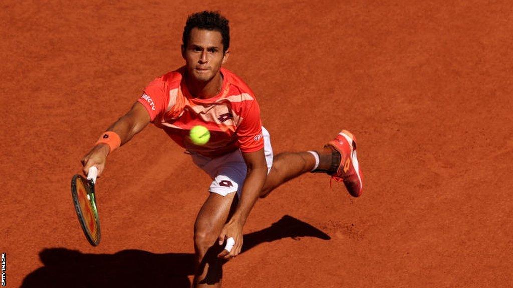 Juan Pablo Varillas stretches for a ball in his French Open match against Novak Djokovic