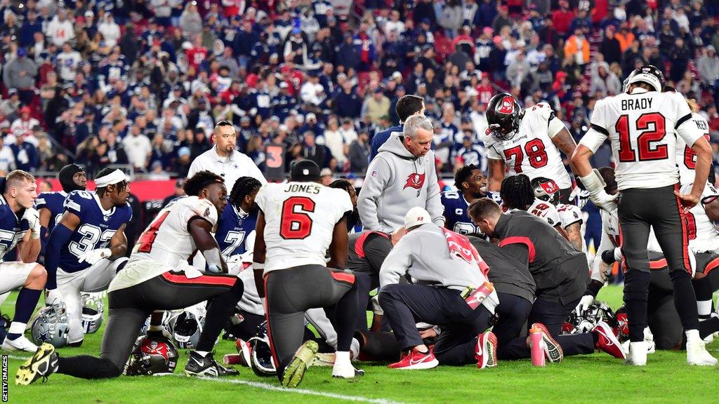 Players knelt around Buccaneers wide receiver Russell Gage