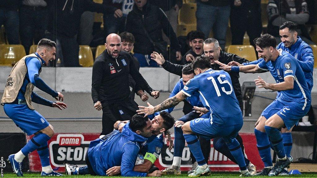 Greece captain Anastasios Bakasetas is mobbed after his equalising goal against France in Euro 2024 qualifying