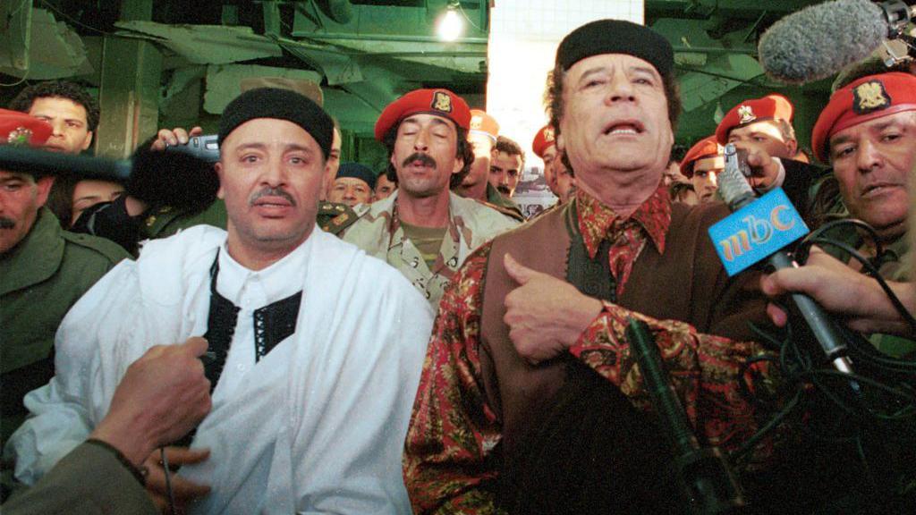 Lockerbie bombing defendant Al-Amin Khalifa Fhimah (L) speaks to the media with Libyan leader Muammar al Gadhafi after arriving a day after being acquitted in the Lockerbie bombing trial February 1, 2001 in Libya, Tripoli.