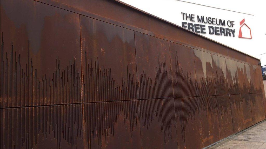 The outside wall shows a sound wave of 'We Shall Overcome'