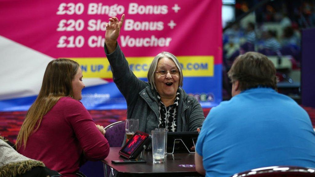 A woman celebrates a win at an indoor bingo hall in July 2020