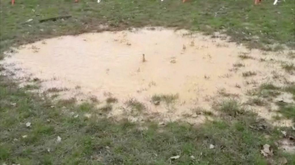 Puddles on a rugby pitch bubbling over