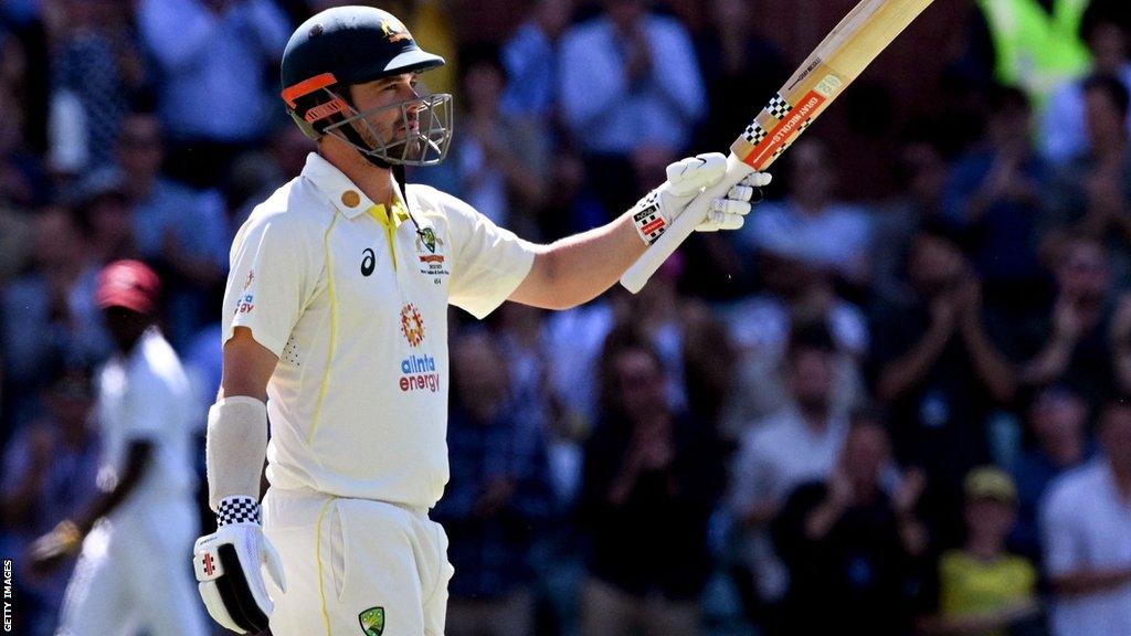 Australia batter Travis Head raises his bat after reaching 150