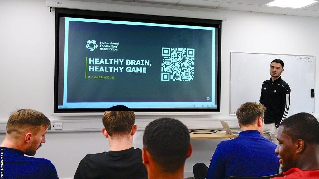 Alex Fletcher (right) delivering a talk to a room of players at Exeter City