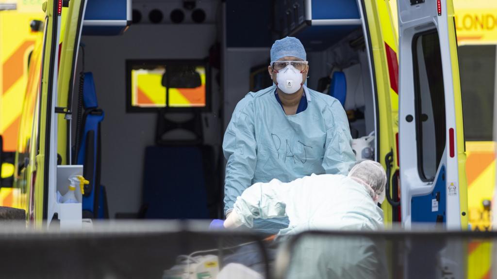 NHS workers in PPE take a patient with an unknown condition from an ambulance at St Thomas' Hospital on April 10, 2020 in London