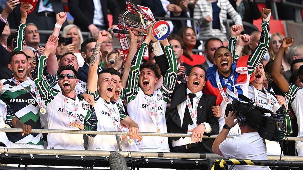 Sunderland's players lift the Championship play-off final winners' trophy in the stand at Wembley Stadium