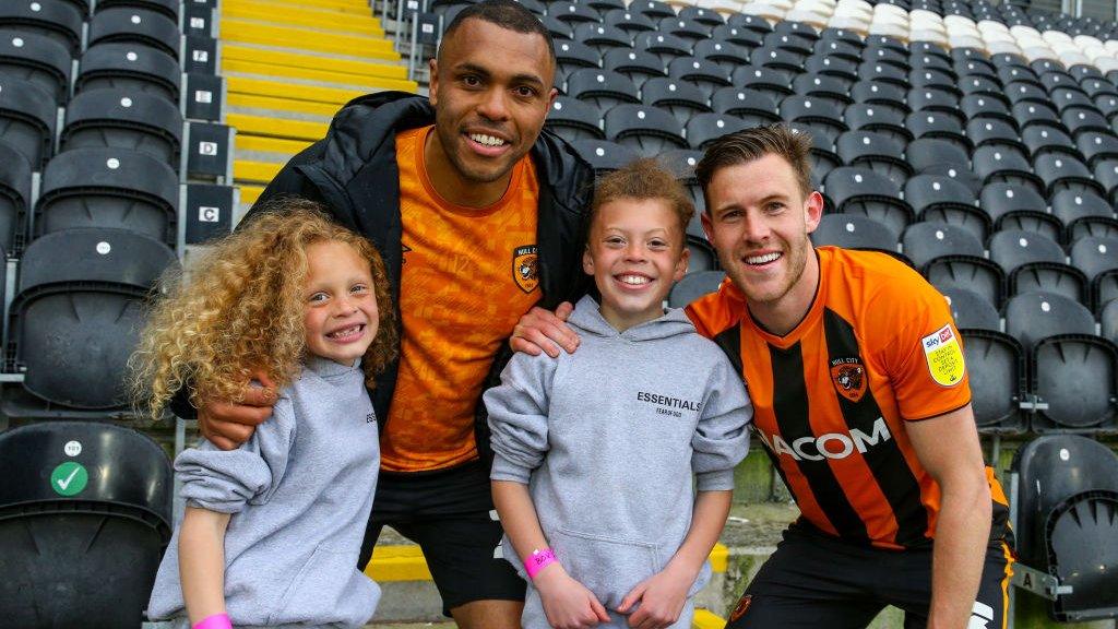 Josh Magennis with his sons Jenson (left) and Cohen (right) celebrating Hull's promotion with Callum Elder