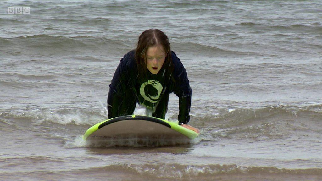 A girl surfing in East Lothian