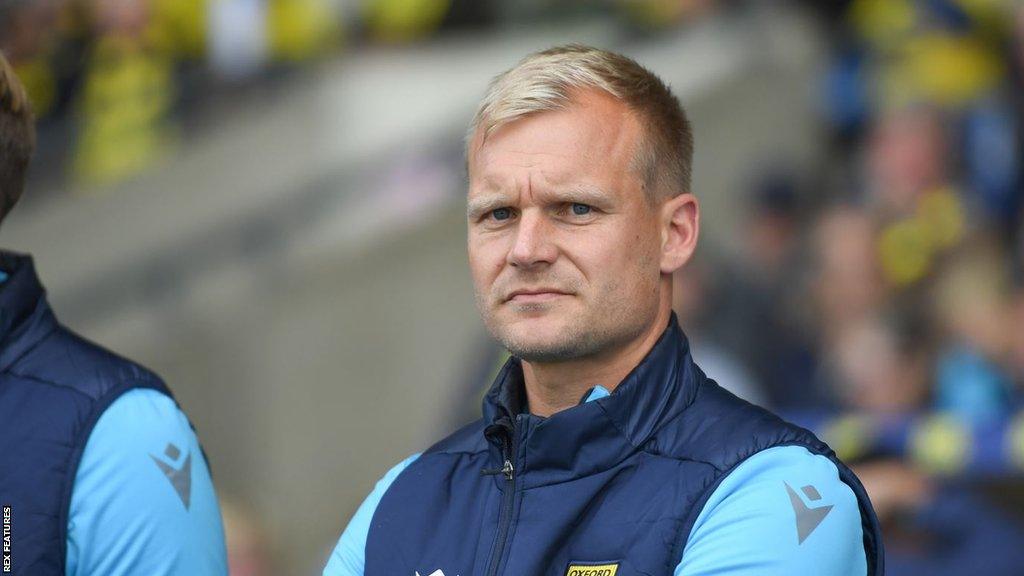 Oxford United head coach Liam Manning looking stressed on the touchline during a League One match.