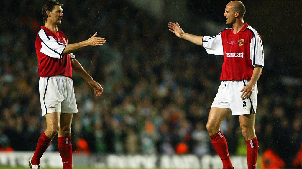 Tony Adams [left] and Steve Bould [right] go to shake hands at Adams' Arsenal testimonial