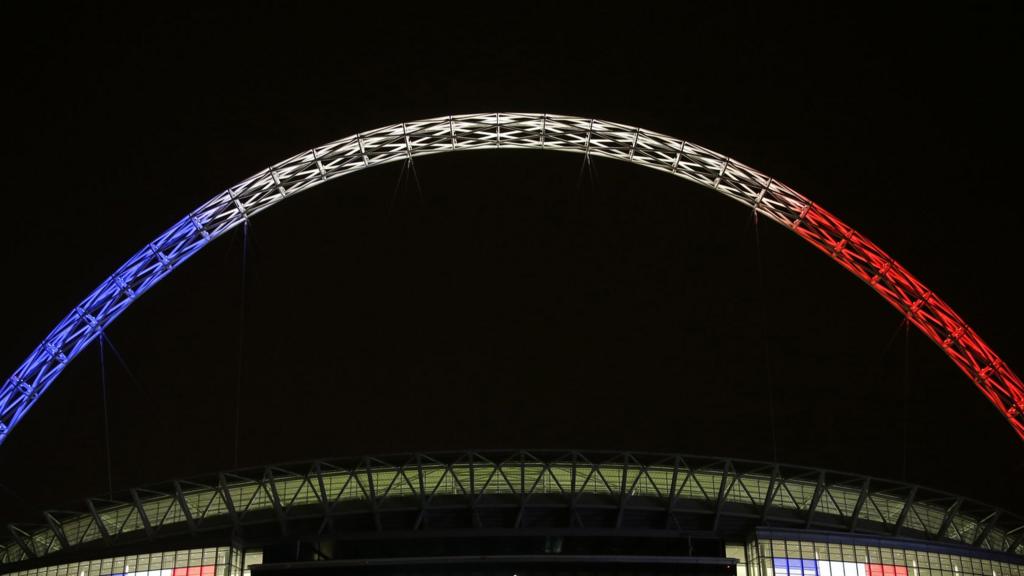 The arch of Wembley Stadium lit up with the French colours