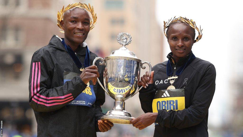 Evans Chebet (left) and Hellen Obiri celebrate with the Boston Marathon trophy