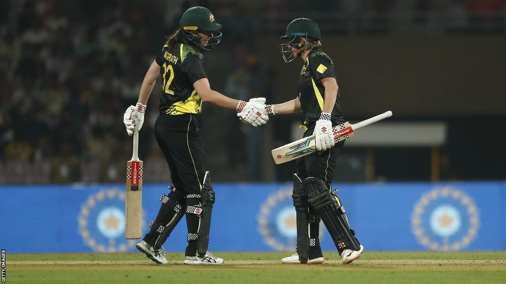 Tahlia McGrath (left) and Beth Mooney shaking hands as they bat against India