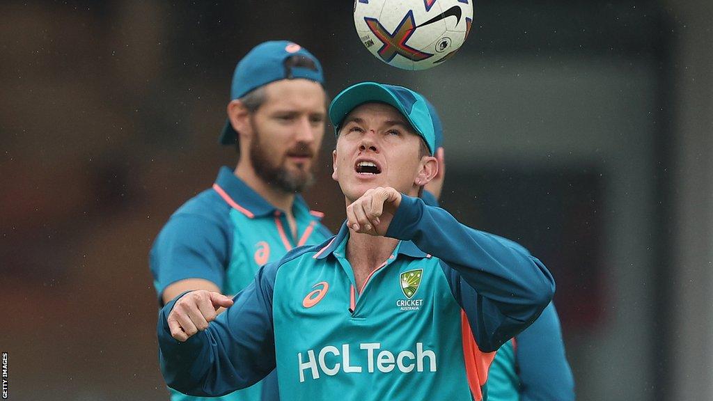 Adam Zampa heads a football in training with cuts visible on his face