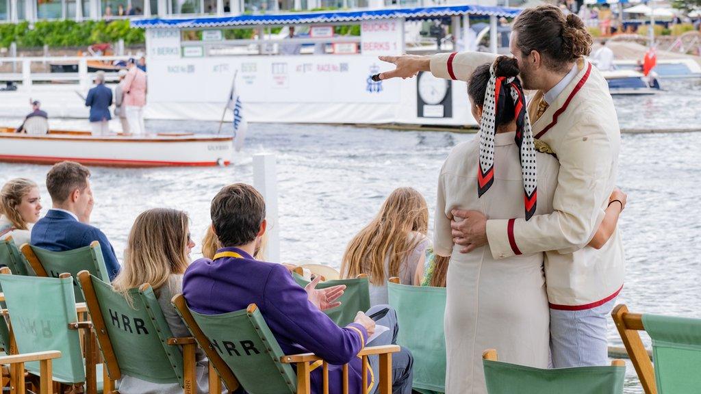 People watch rowers on the river at the Henley Royal Regatta