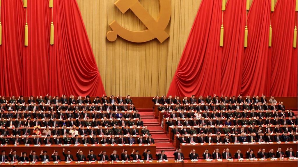 Delegates raise their hands as they take a vote during the closing ceremony of the 19th National Congress of the Communist Party of China (CPC)