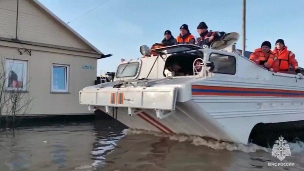 Rescuers search for residents while driving through flooded area