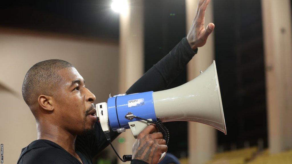 Presnel Kimpembe speaks to PSG fans through a megaphone