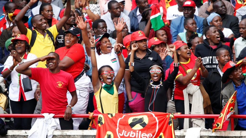 People cheer as they wait for the inauguration ceremony to swear in Kenya's President Uhuru Kenyatta at Kasarani Stadium in Nairobi