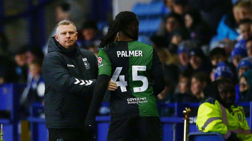 Mark Robins (left) embraces Kasey Palmer