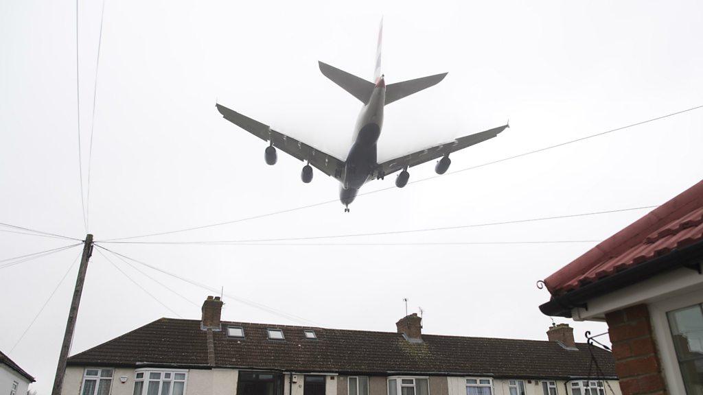 A plane flying over houses