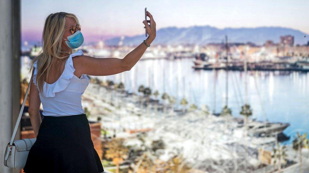 Woman taking a selfie wearing a face mask in Malaga.