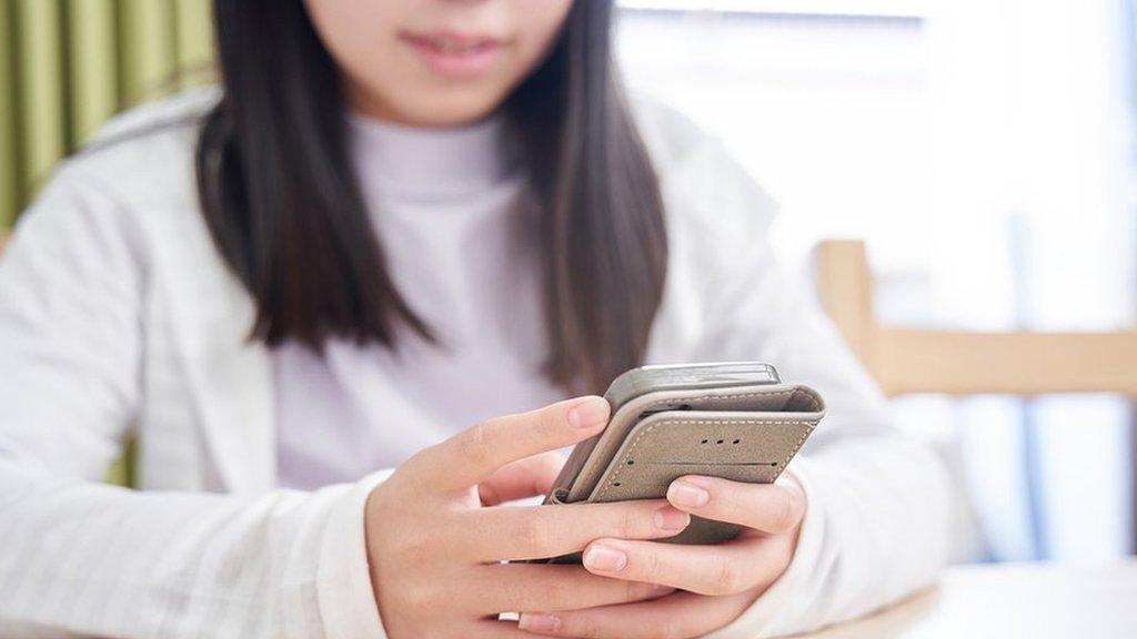 A stock photo of a girl using a phone