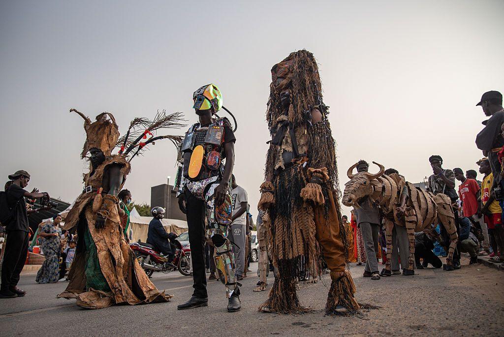 People wear elaborate costumes, some are chrome and futuristic in appearance, Others feature lots of hanging layers and attenae.