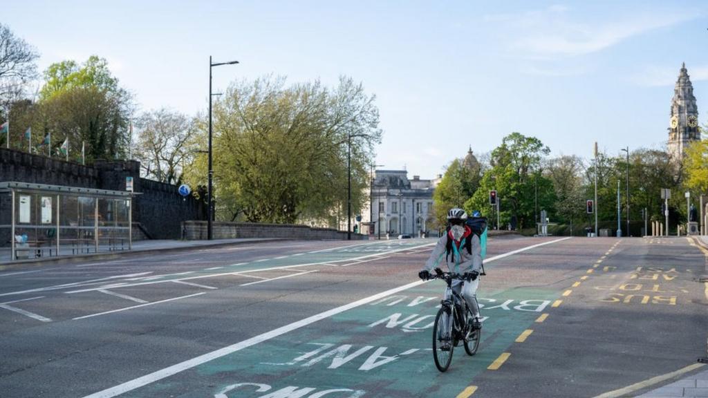 Food delivery cyclist wearing mask in Cardiff