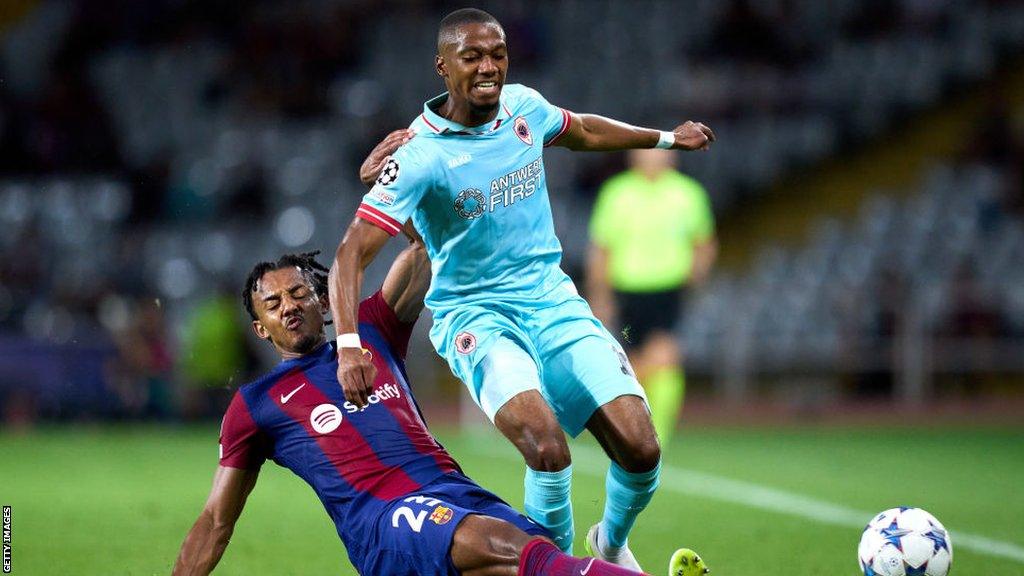 Jules Kounde of Barcelona tackles Royal Antwerp player Michel-Ange Balikwisha