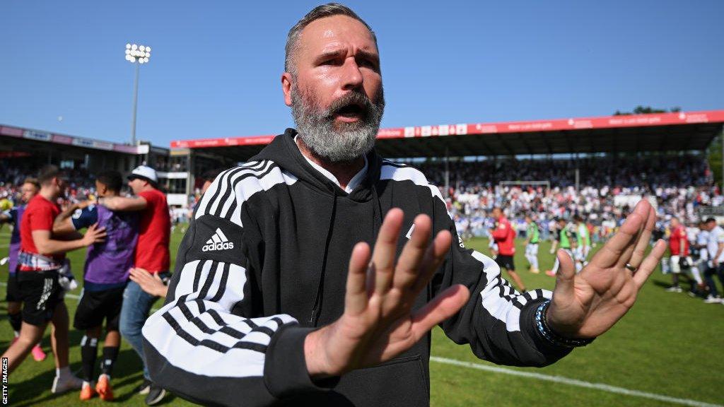 Hamburg head coach Tim Walter appeals for calm as supporters ran on to the pitch