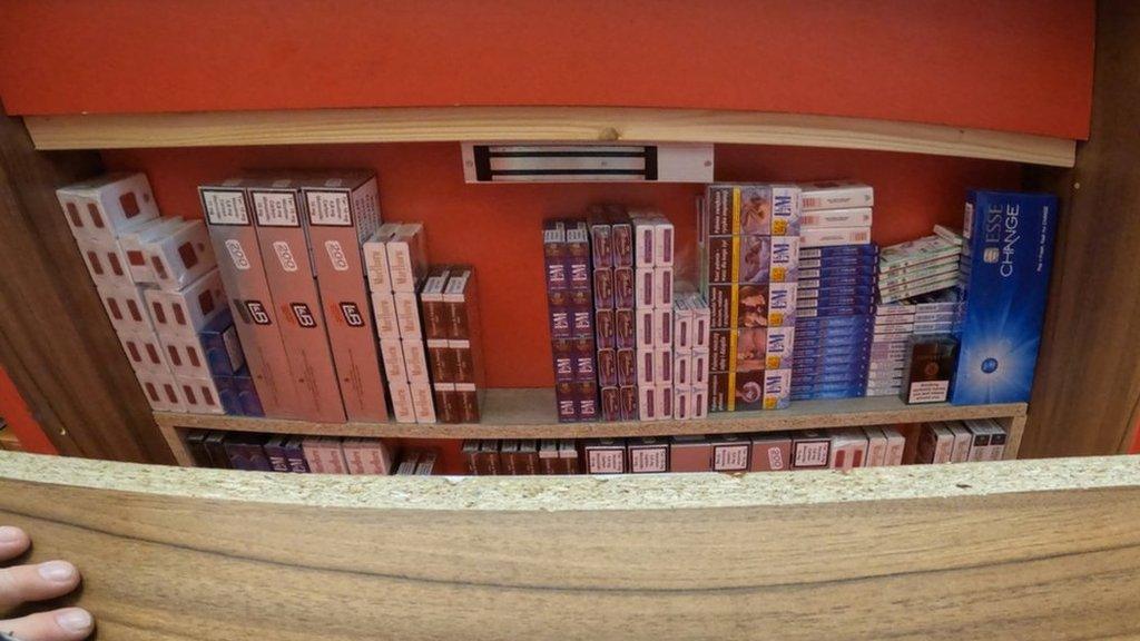 Illegal tobacco products hidden behind a shelf