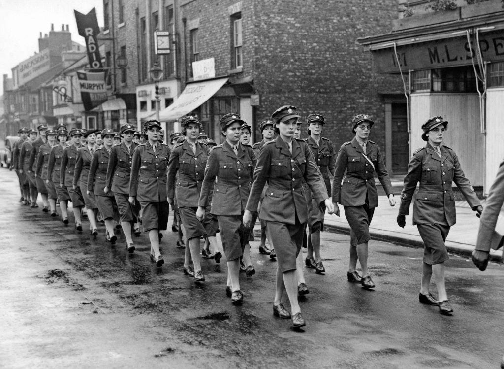 A VE Day parade of uniformed servicewomen marching down the street