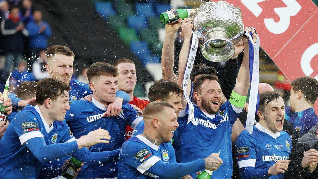 Jamie Mulgew lifts the trophy as Linfield begin their celebrations at Windsor Park